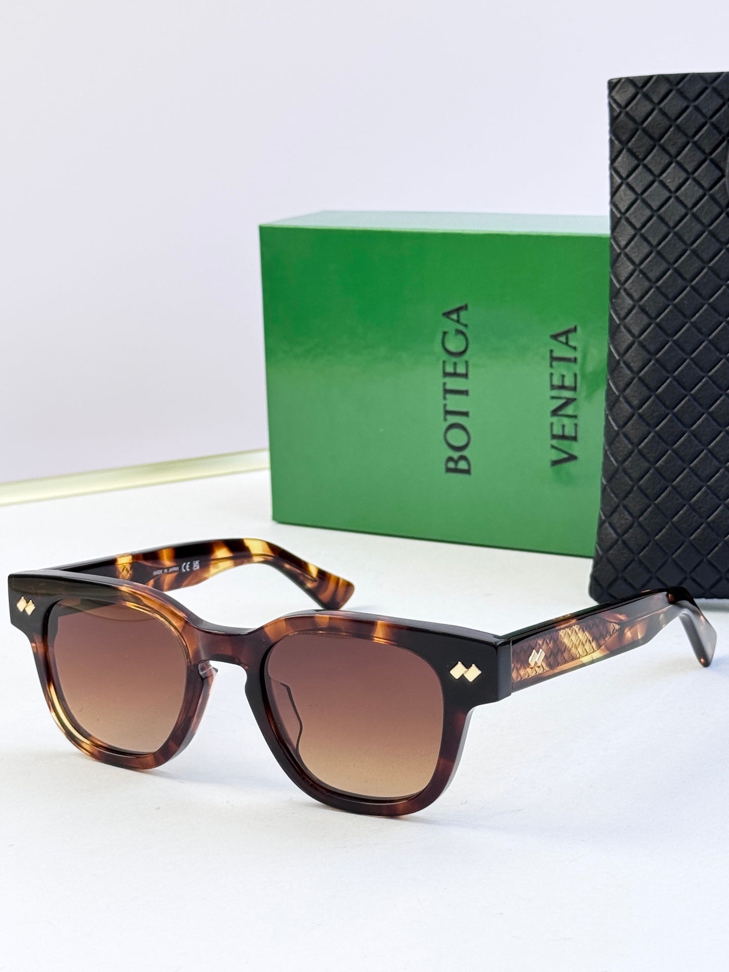Sunglasses with tortoiseshell frames, gold textured temples, and brown tinted lenses