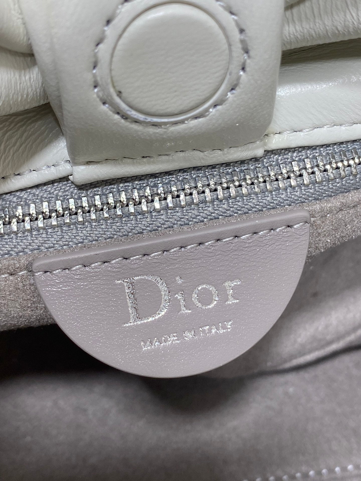 Ivory leather Dior handbag zipper pull with 'Dior' logo patch