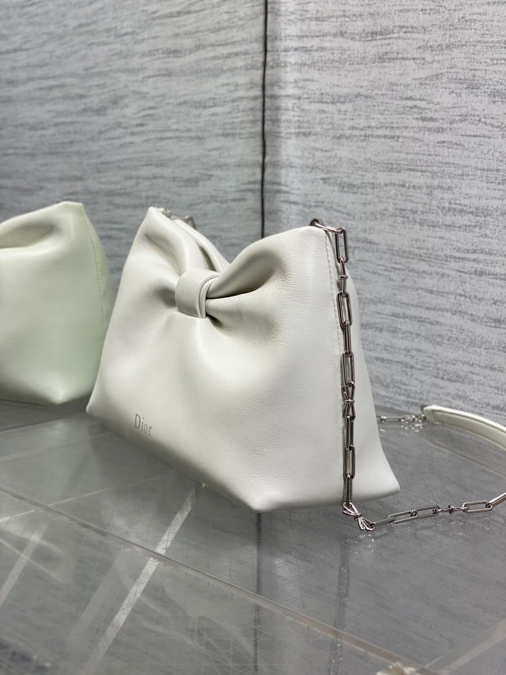 Ivory leather Dior handbag with bow front, chain strap, and back panel