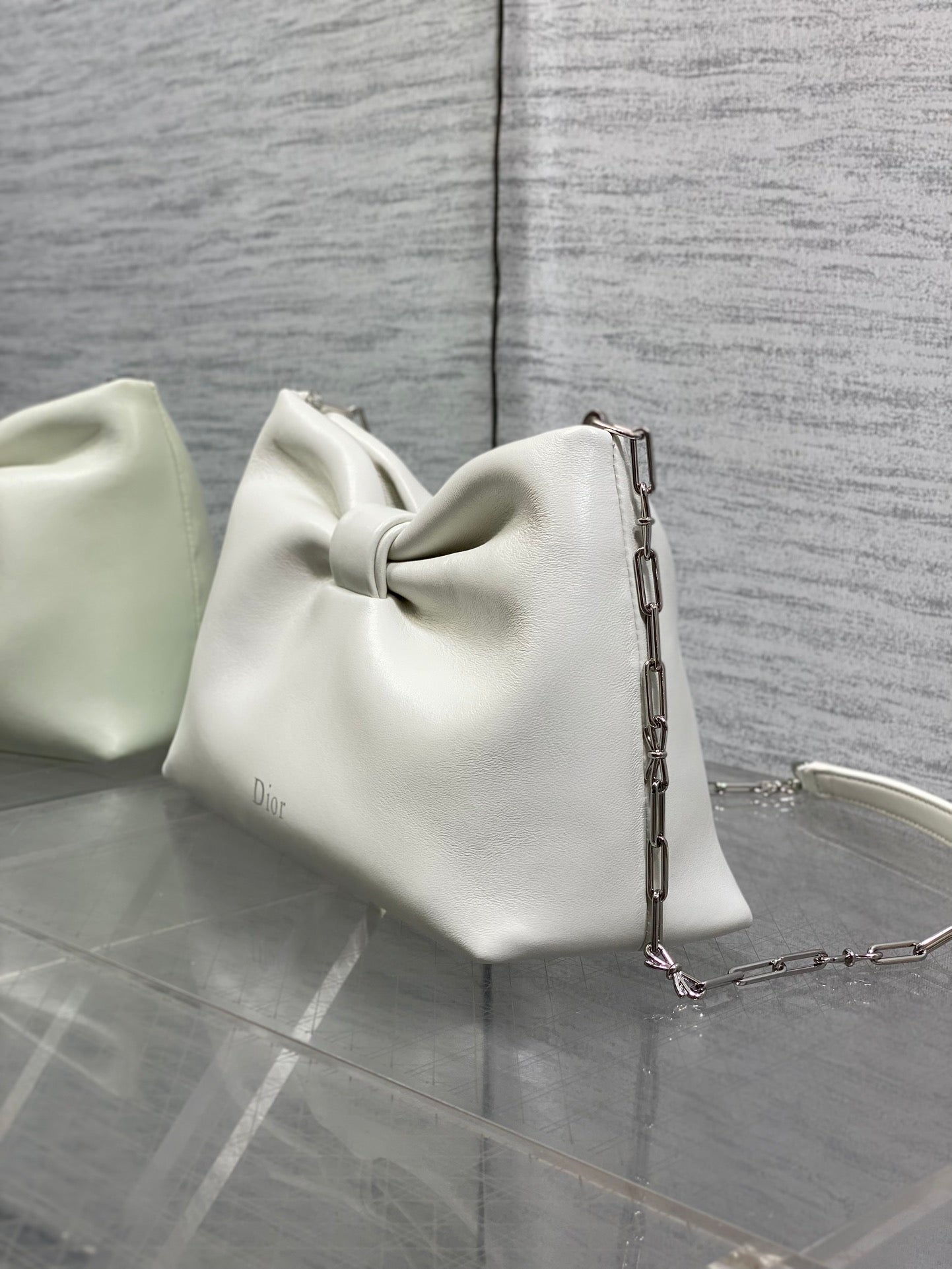 Ivory leather Dior handbag with bow front, chain strap, and back panel