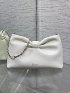 Ivory leather Dior bow handbag with silver chain strap and curved silhouette
