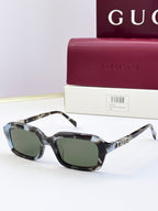 Mottled dark Gucci sunglasses with square frames and dark green-tinted lenses.