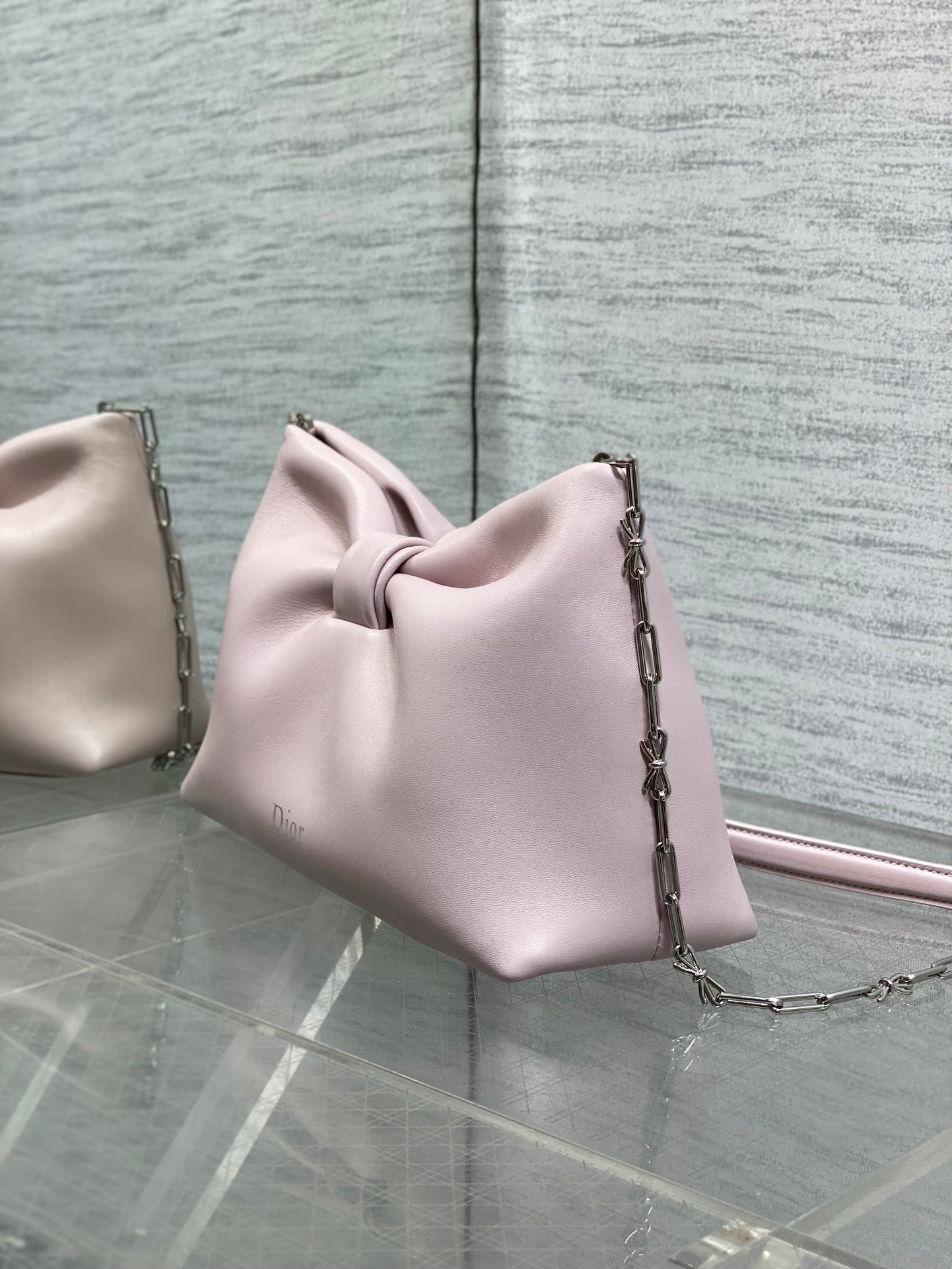 Light pink Dior bow bag angled view with chain strap