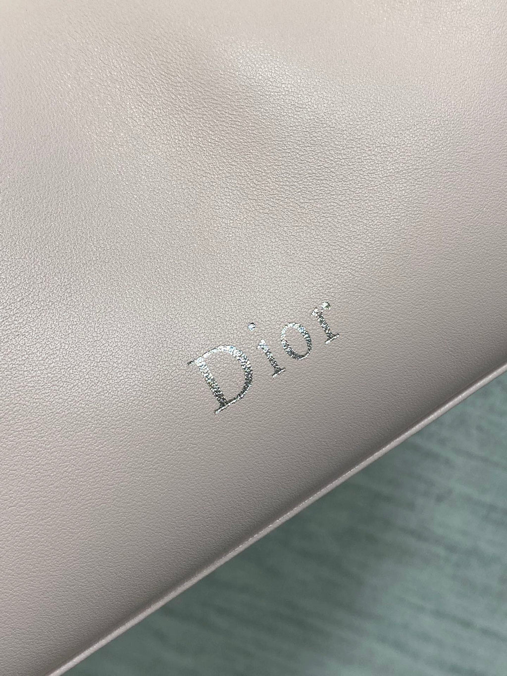 Light pink Dior logo emboss on leather bag side panel