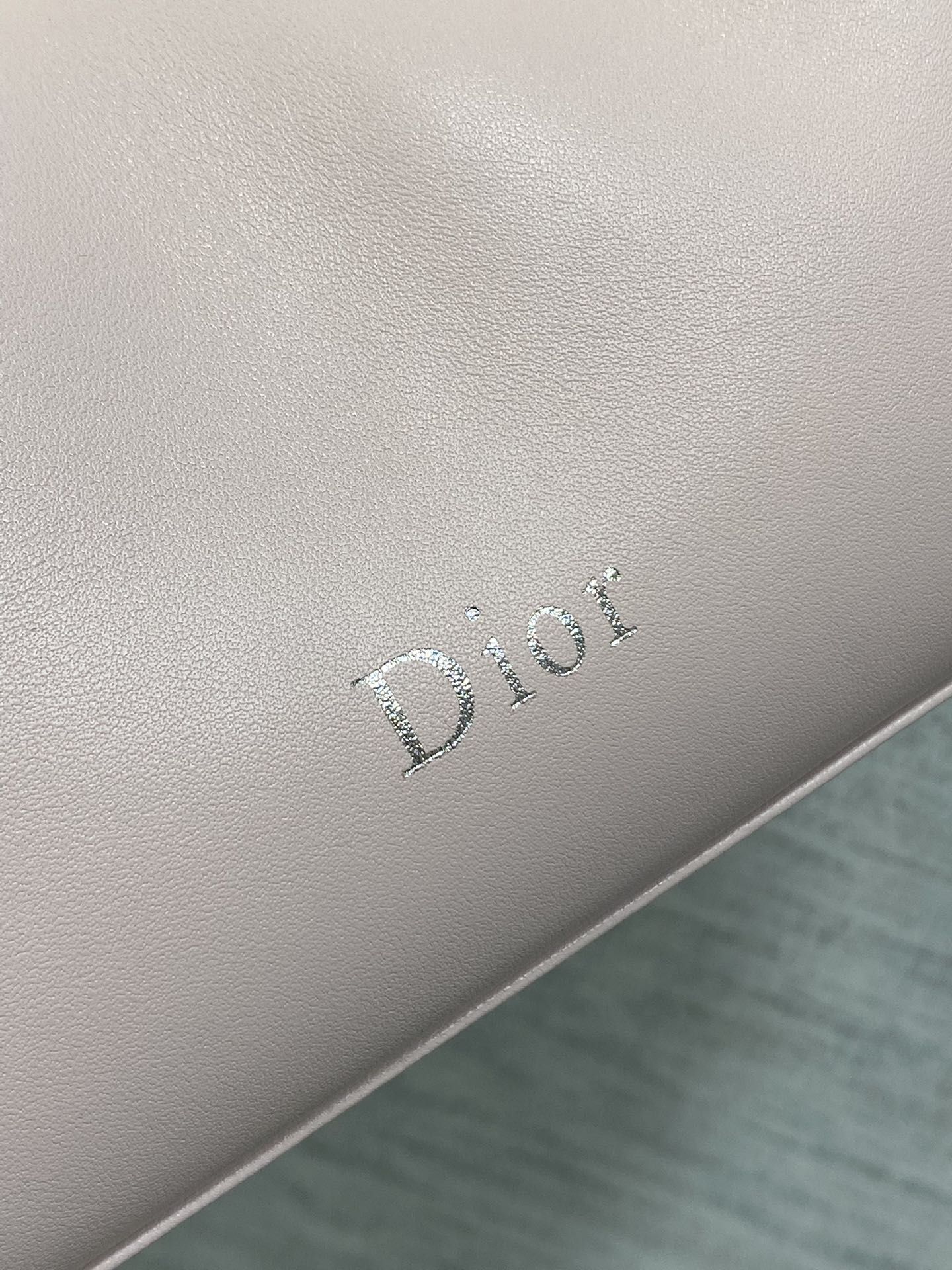 Light pink Dior logo emboss on leather bag side panel