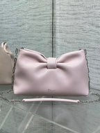 Light pink Dior bow bag with top handle and chain strap, logo on front