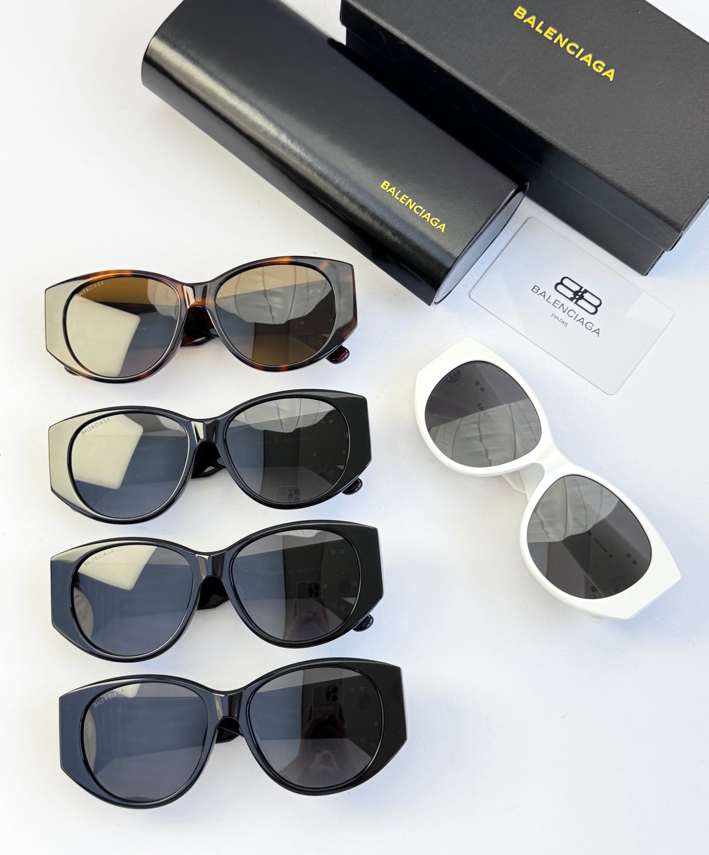 Assorted sunglasses set with dark, tortoise, and white frames plus cases