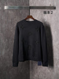 Black knit crewneck sweater with long sleeves and embossed monogram motifs