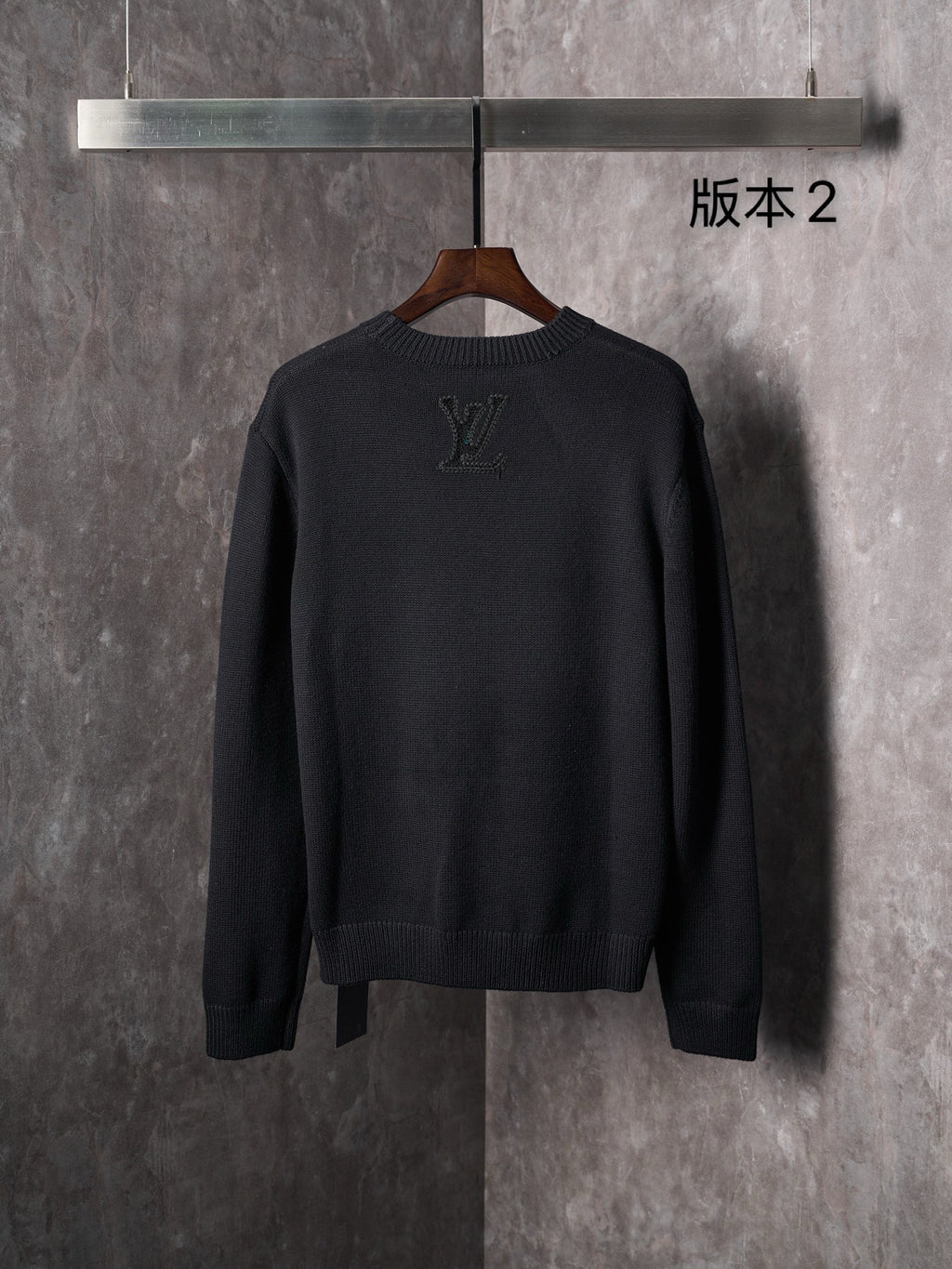Black knit crewneck sweater back view with embossed monogram motifs