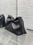 Black leather Dior bow bag with gold chain strap and Dior logo stamp