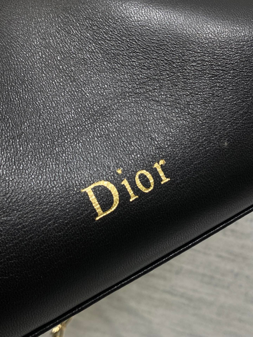 Black leather panel with gold Dior logo text