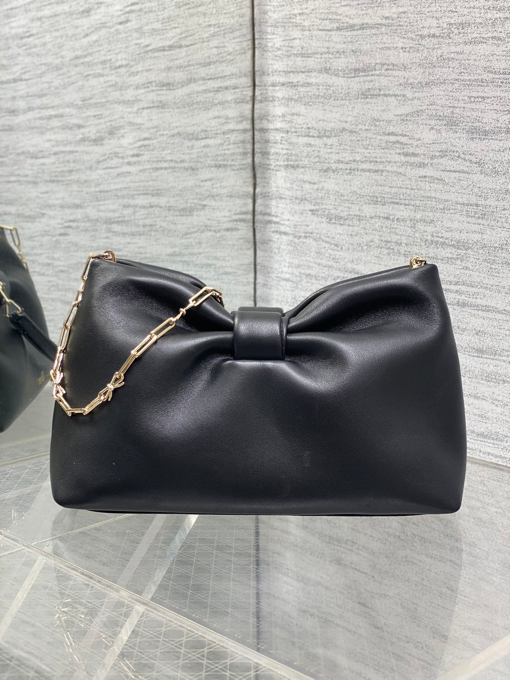 Black leather Dior bow shoulder bag with gold chain strap and Dior logo