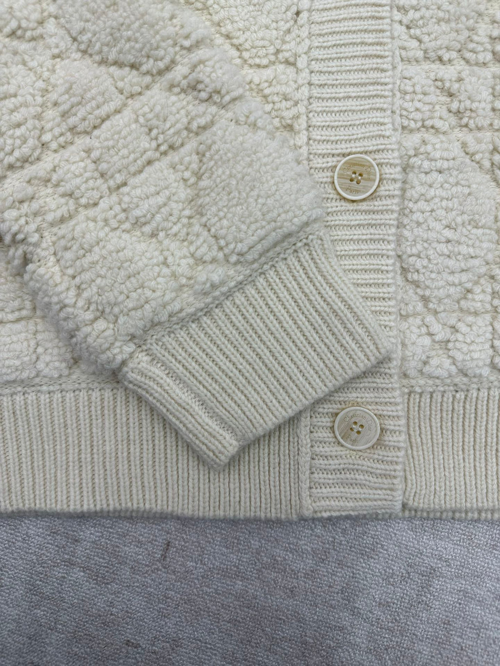 Cream knit Dior jacket front with button placket and ribbed cuffs