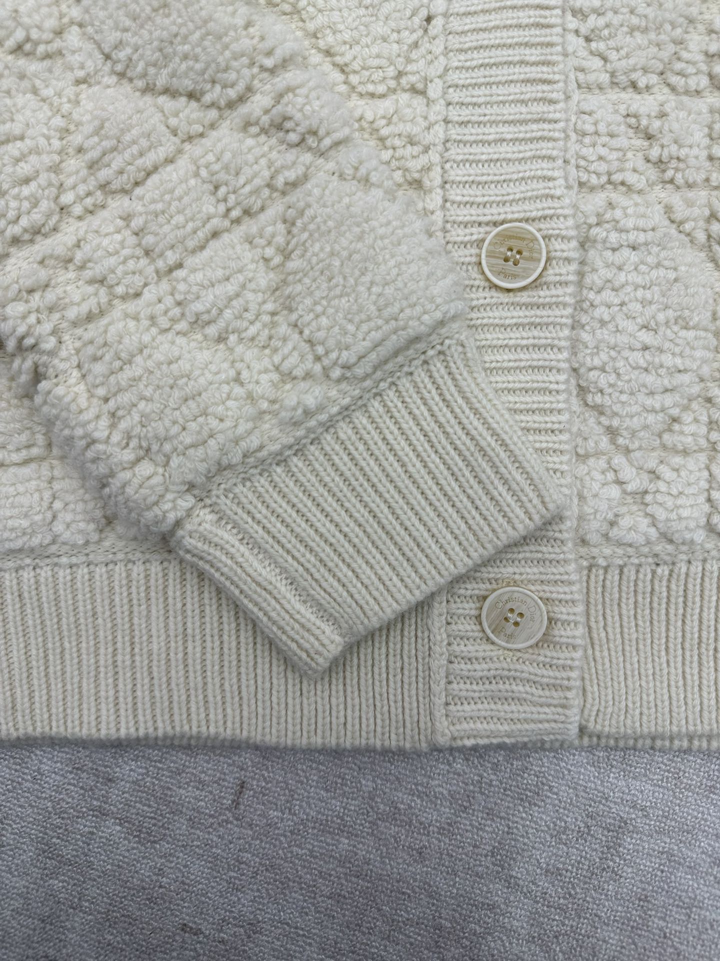 Cream knit Dior jacket front with button placket and ribbed cuffs