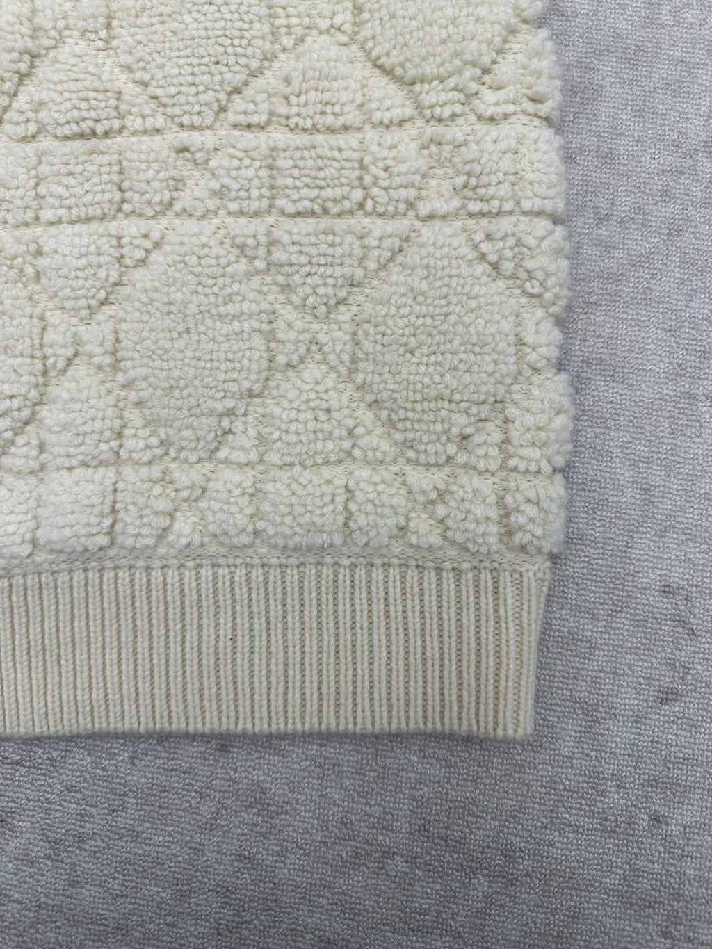 Cream knit Dior jacket bottom hem with ribbed band and textured fabric panel