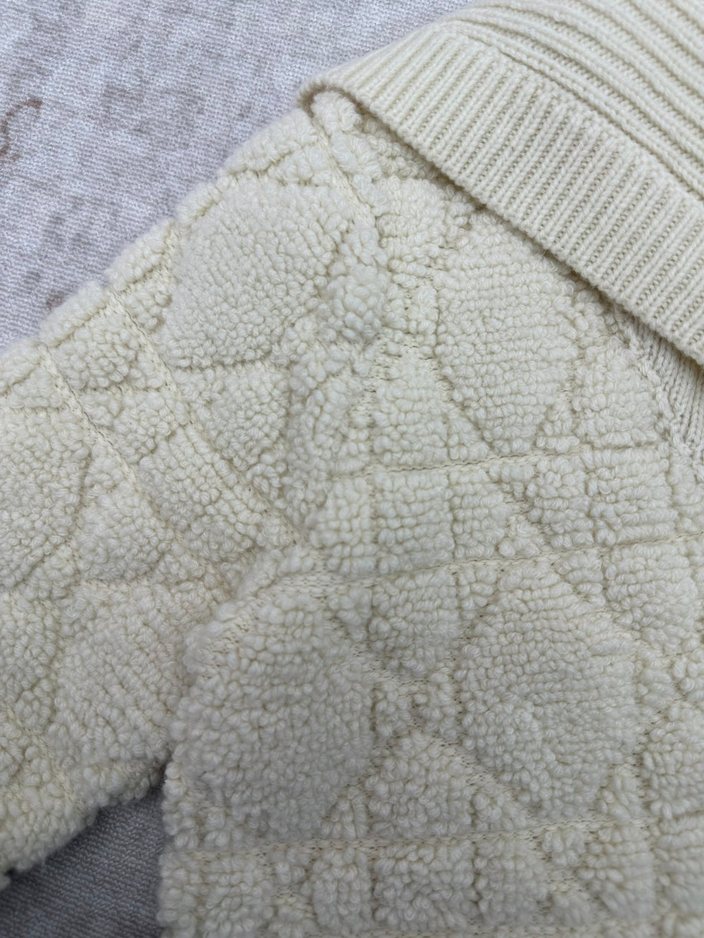 Cream teddy-textured Dior jacket sleeve and shoulder with ribbed knit trim