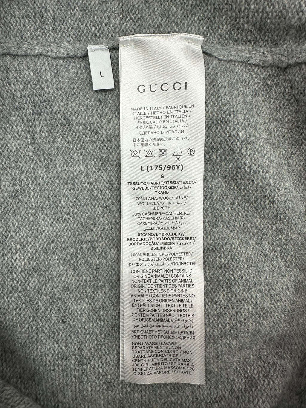 Gucci clothing care and material tag on gray knit cardigan