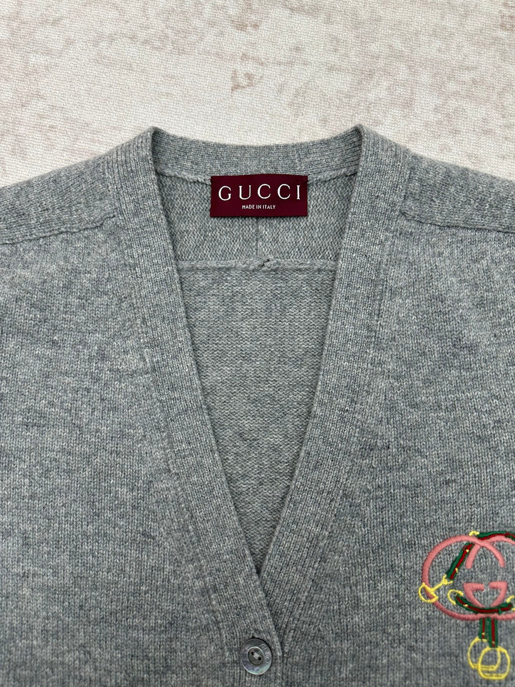 Gucci gray knit cardigan neckline close-up with inner Gucci label and logo detail