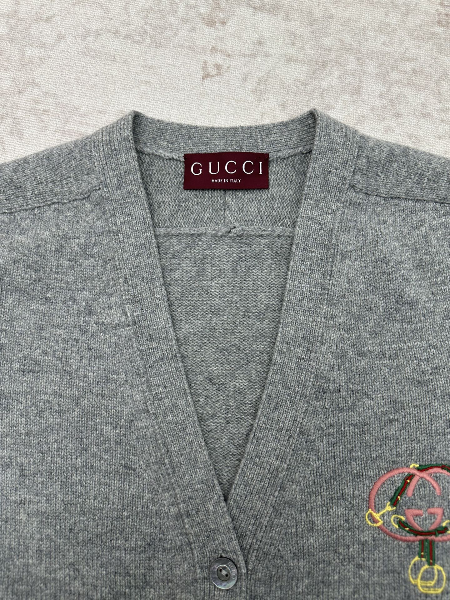 Gucci gray knit cardigan neckline close-up with inner Gucci label and logo detail