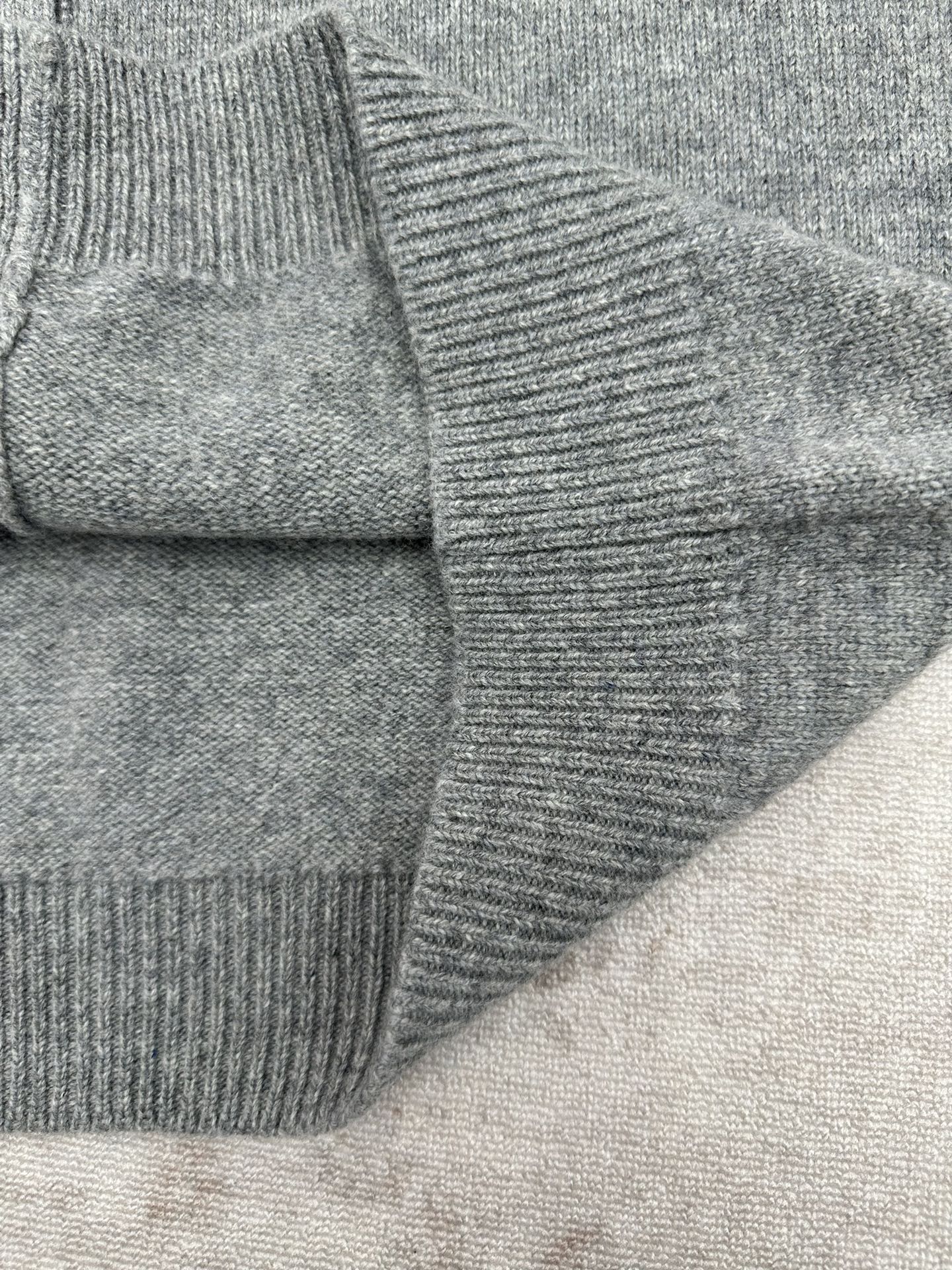 Gucci gray knit cardigan sleeve and shoulder seam close-up with ribbed cuff
