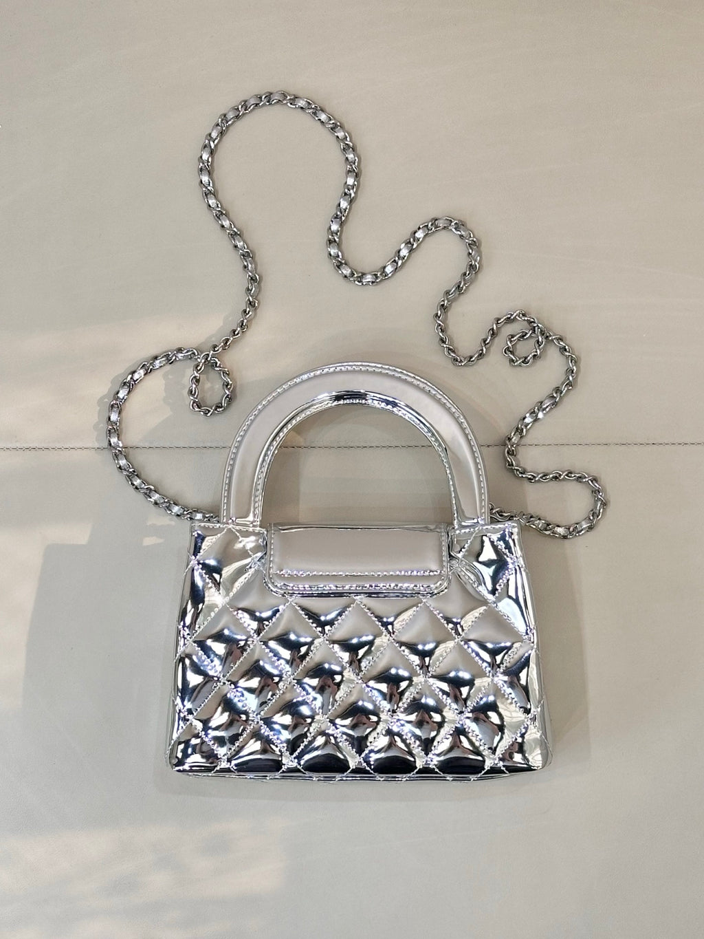 Chanel silver quilted mini bag front view with chain shoulder strap and curved handles