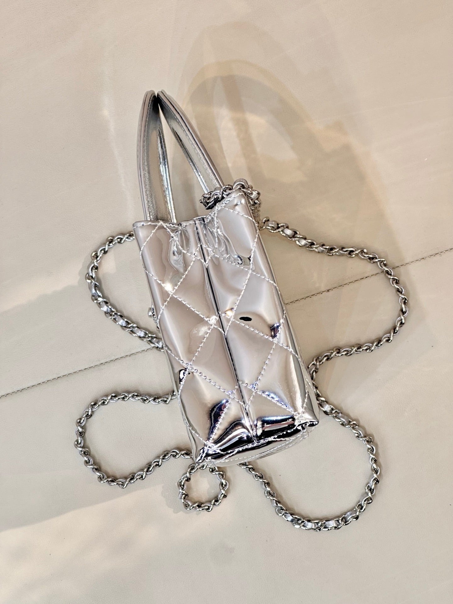 Chanel silver quilted mini bag back view with top handles and chain strap