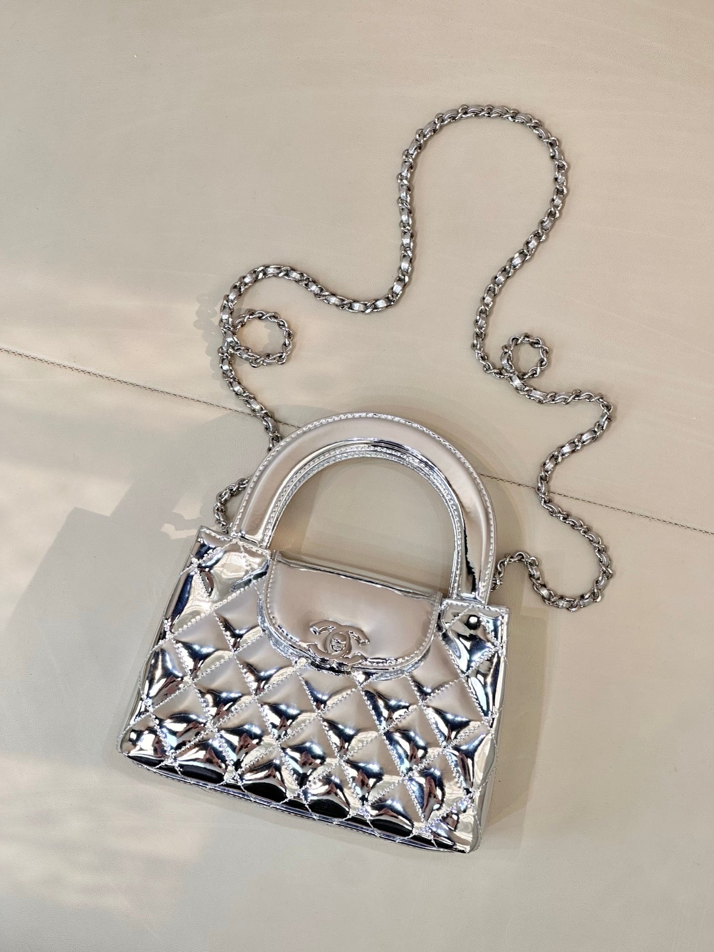 Chanel silver quilted mini bag, front view, top handle and chain strap