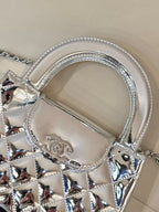 Chanel silver quilted bag detail: arched top handle, logo plaque, chain links