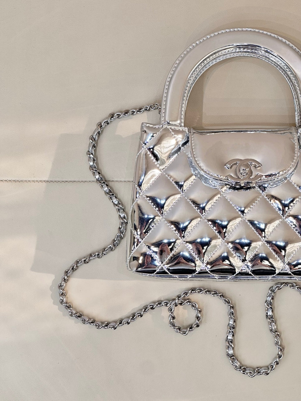 Chanel silver quilted mini bag close-up with logo plaque and double top handles