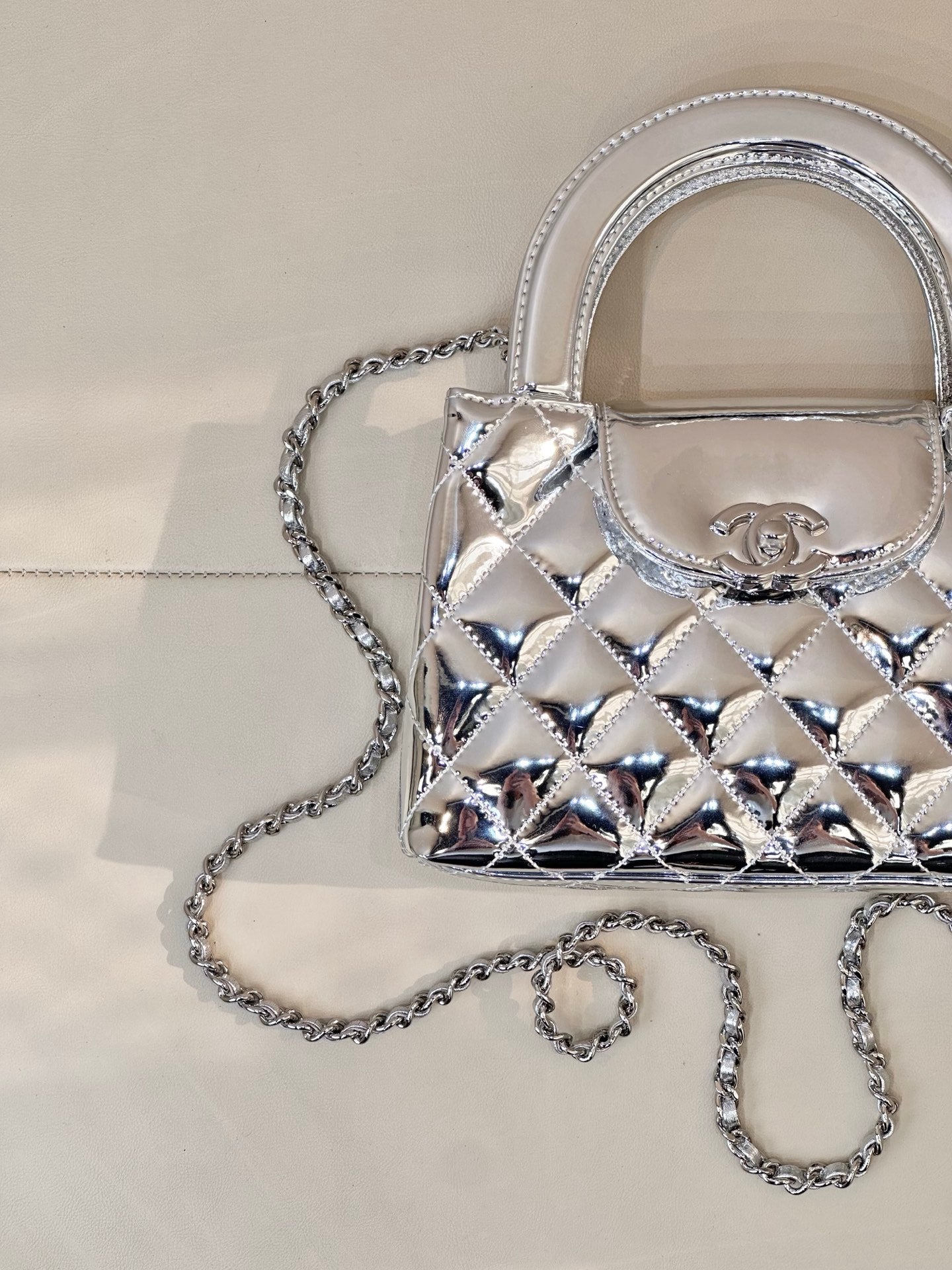 Chanel silver quilted mini bag close-up with logo plaque and double top handles