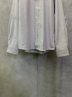 Striped button-up shirt with long sleeves and button front, hem cuff details visible