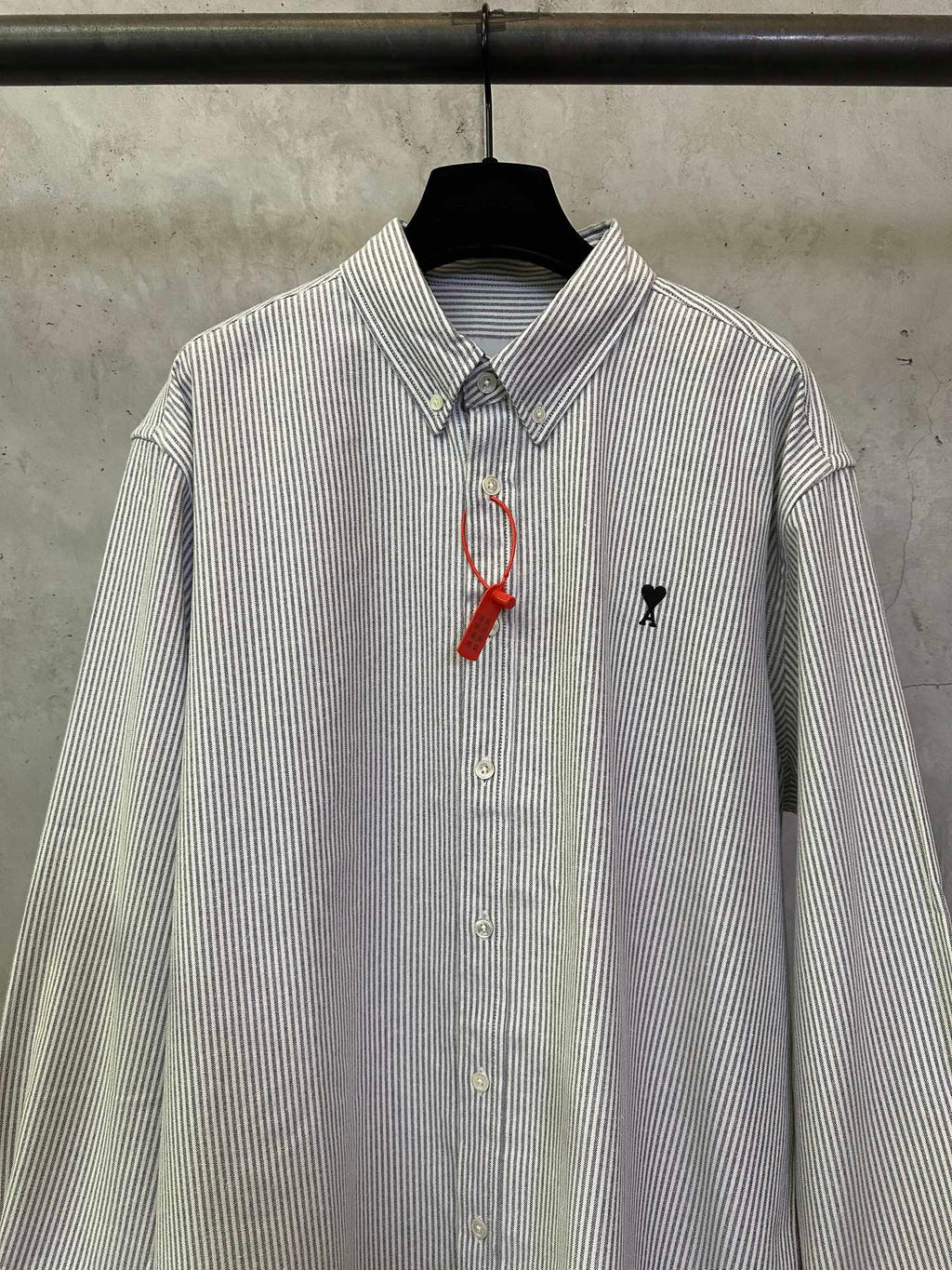 Striped button-up shirt with point collar, front buttons, and red-and-black chest emblem