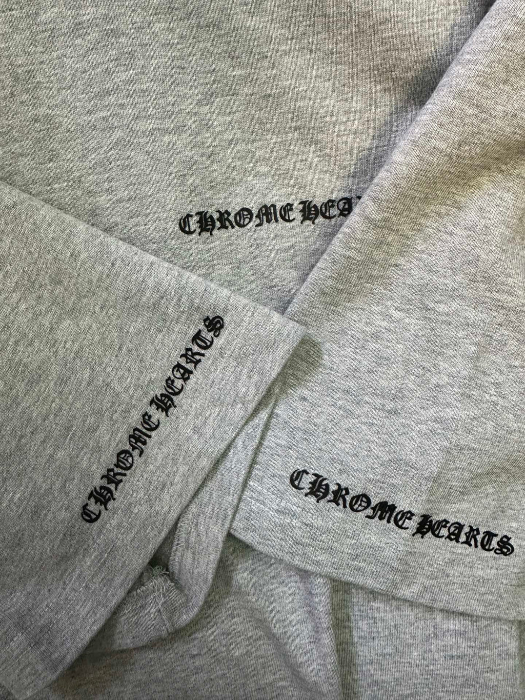 Heather gray T-shirt sleeves with Chrome Hearts logo prints on cuffs