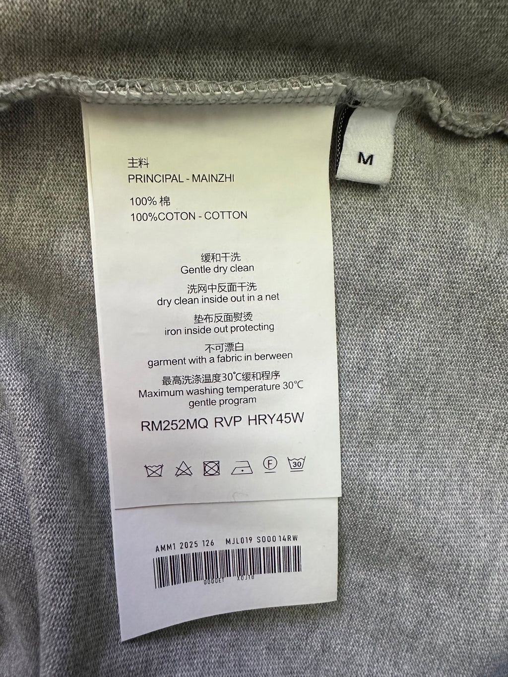 T-shirt care label with size M and cotton fabric content