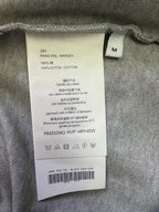 T-shirt care label with size M and cotton fabric content