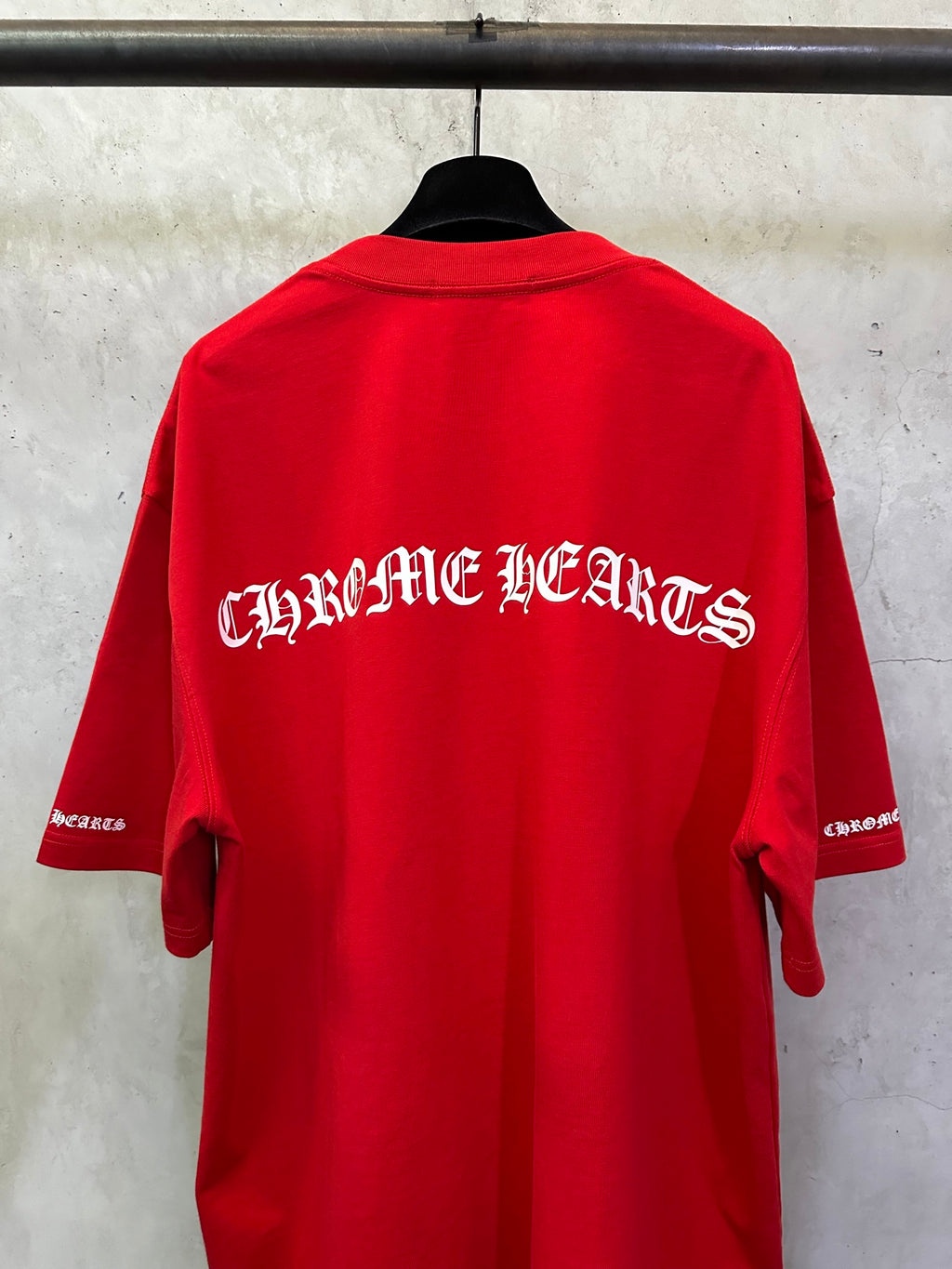 Red short-sleeve T-shirt with large back “Chrome Hearts” graphic.