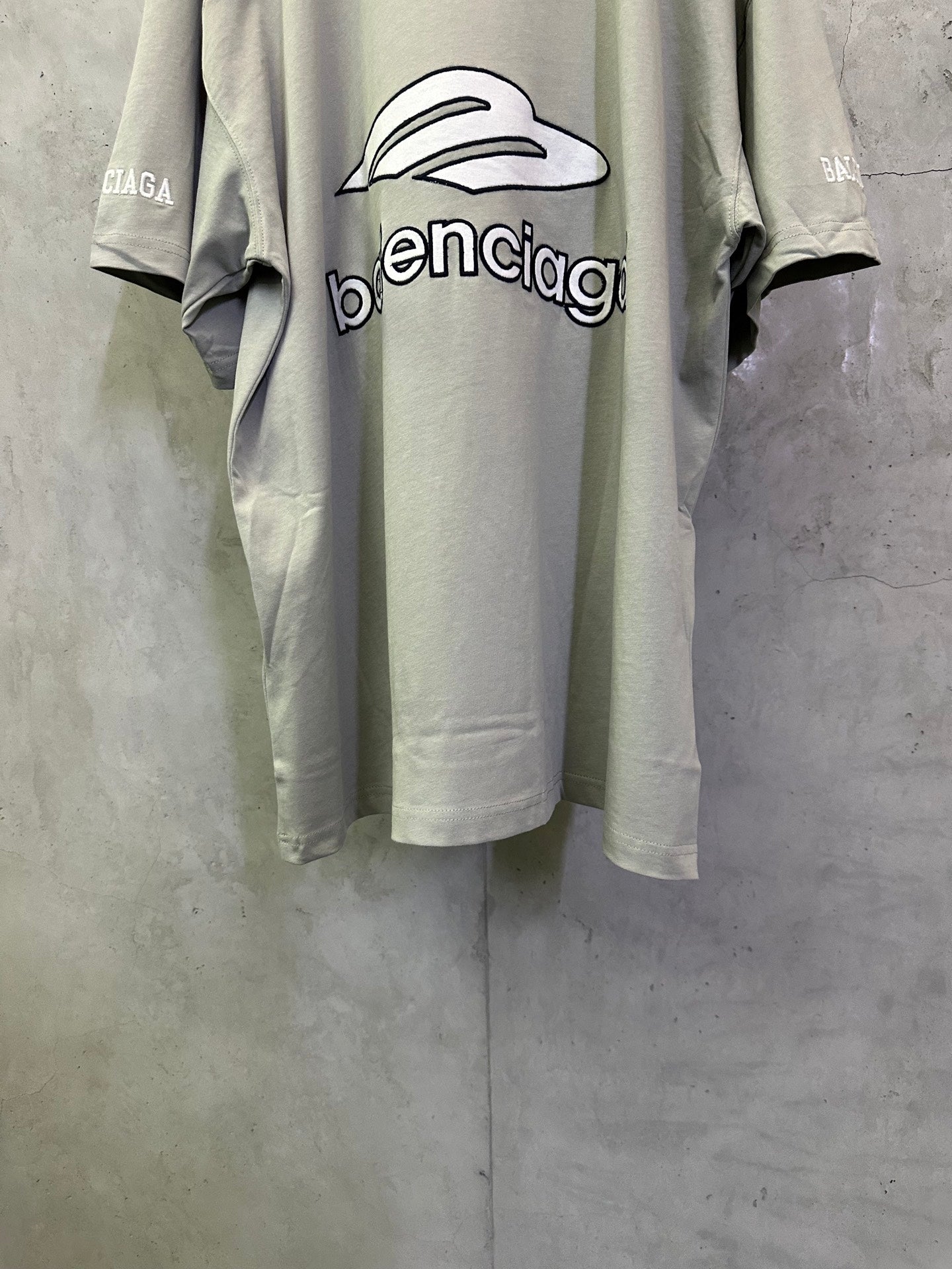 Light sage short-sleeve T-shirt back view with oversized balenciaga logo print