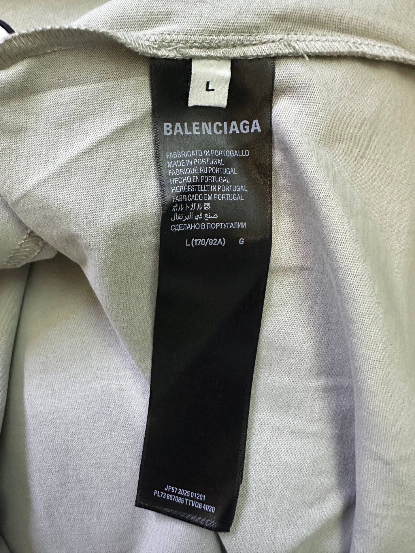 Interior neck label on light sage T-shirt with size L and brand details