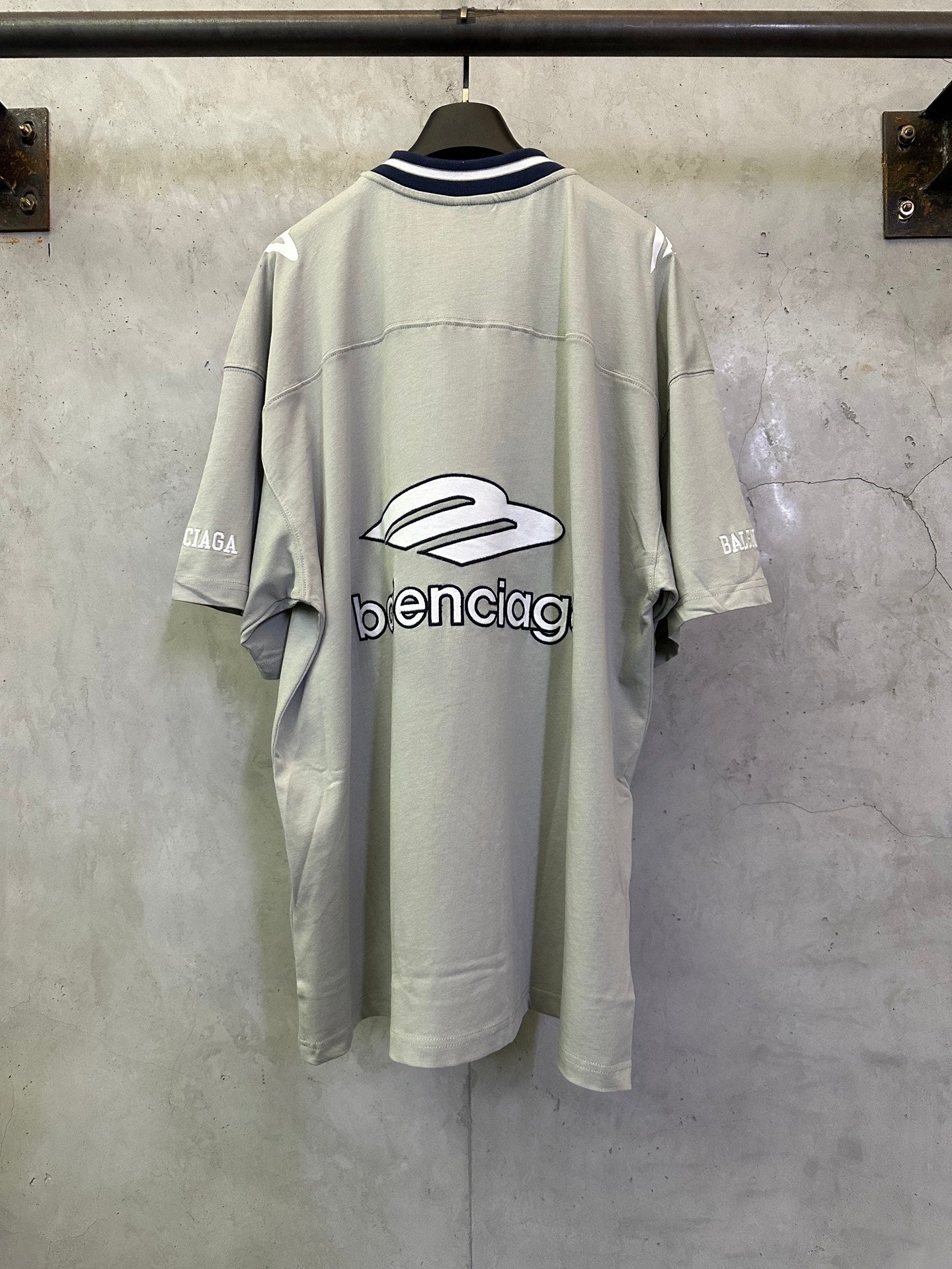 Back view light sage short-sleeve T-shirt with large balenciaga logo graphic