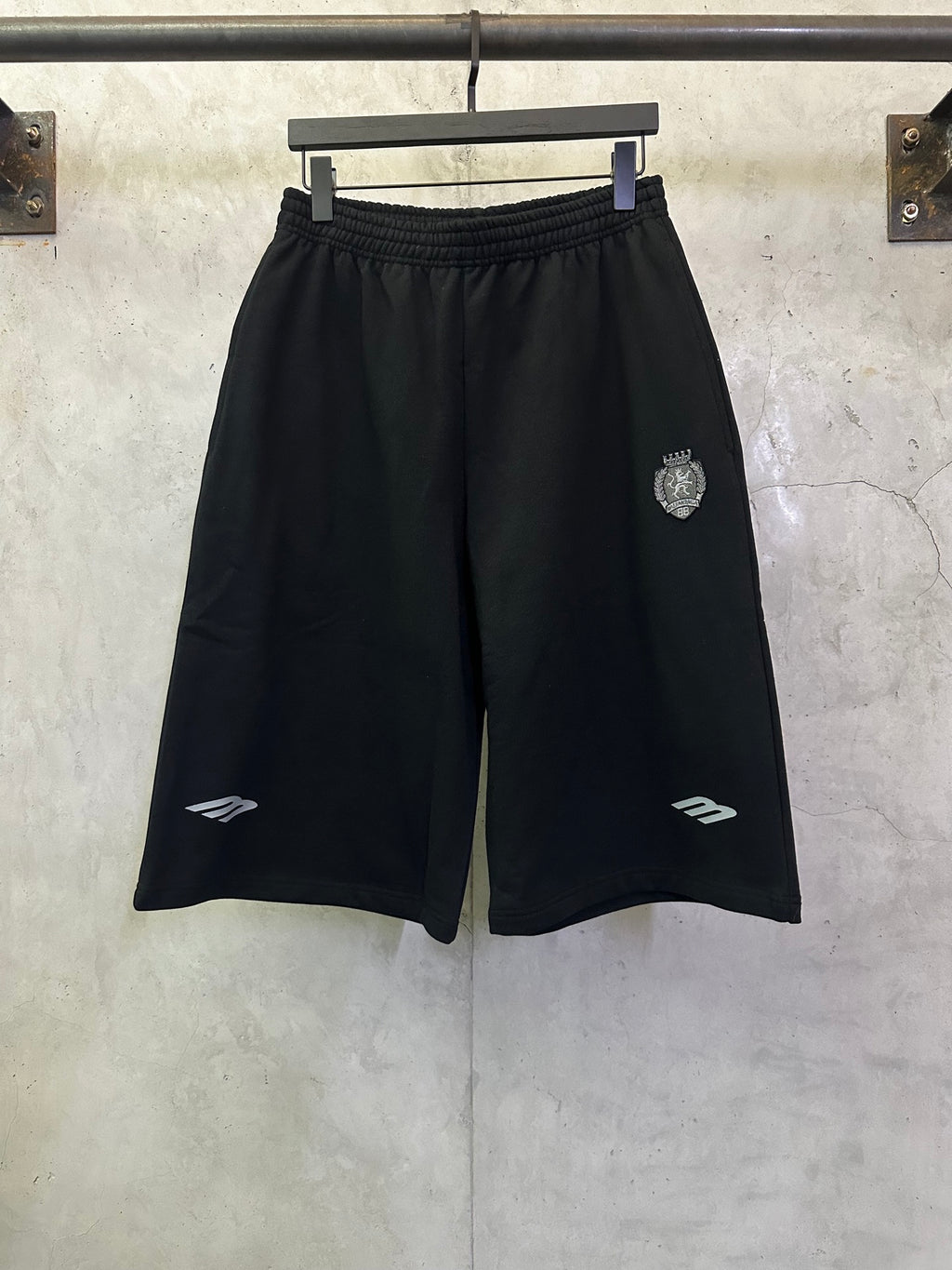 Black athletic shorts with elastic waistband and side logo details