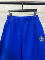 Blue drawstring waist shorts with embroidered side crest patch