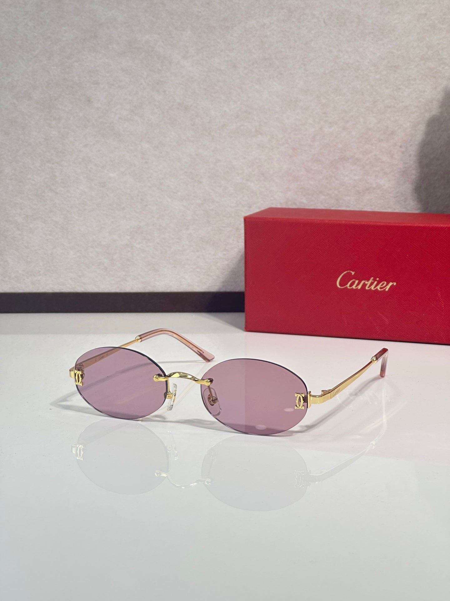 Sunglasses with round purple lenses and gold-tone frame with thin metal temples