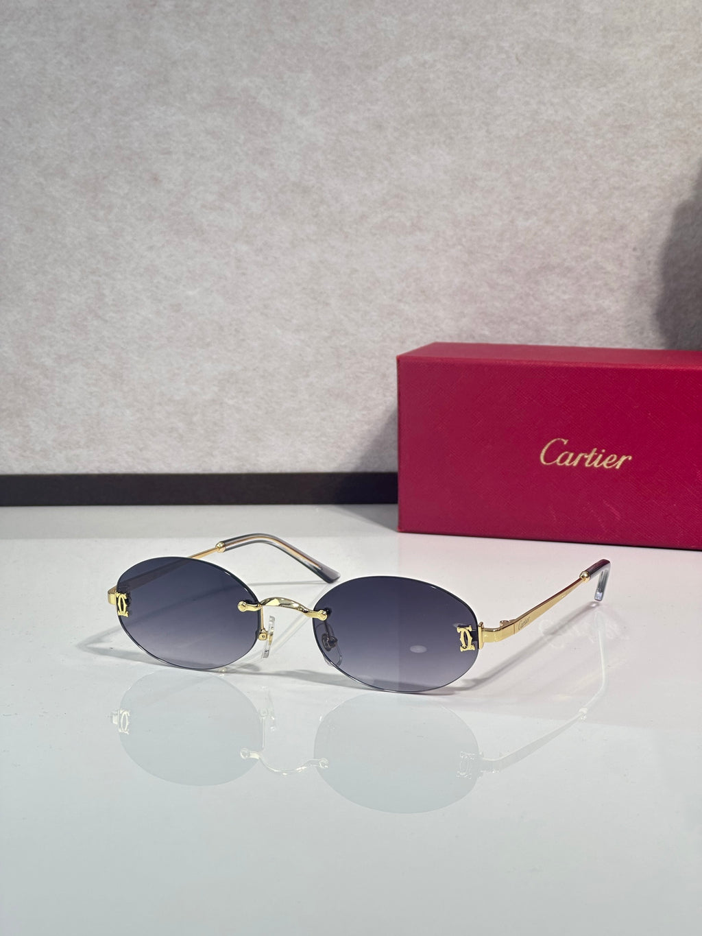 Sunglasses with round navy lenses and gold-tone frame with dark metal temples