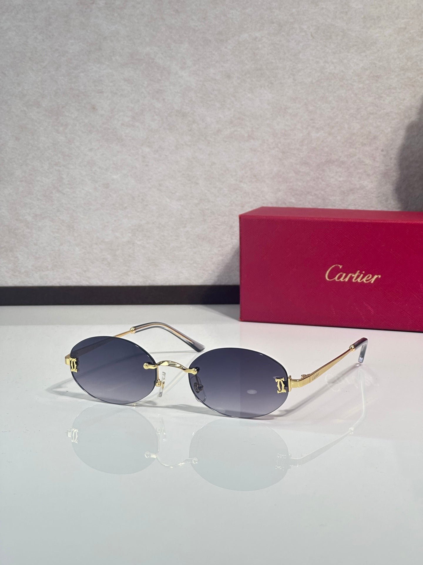 Sunglasses with round navy lenses and gold-tone frame with dark metal temples