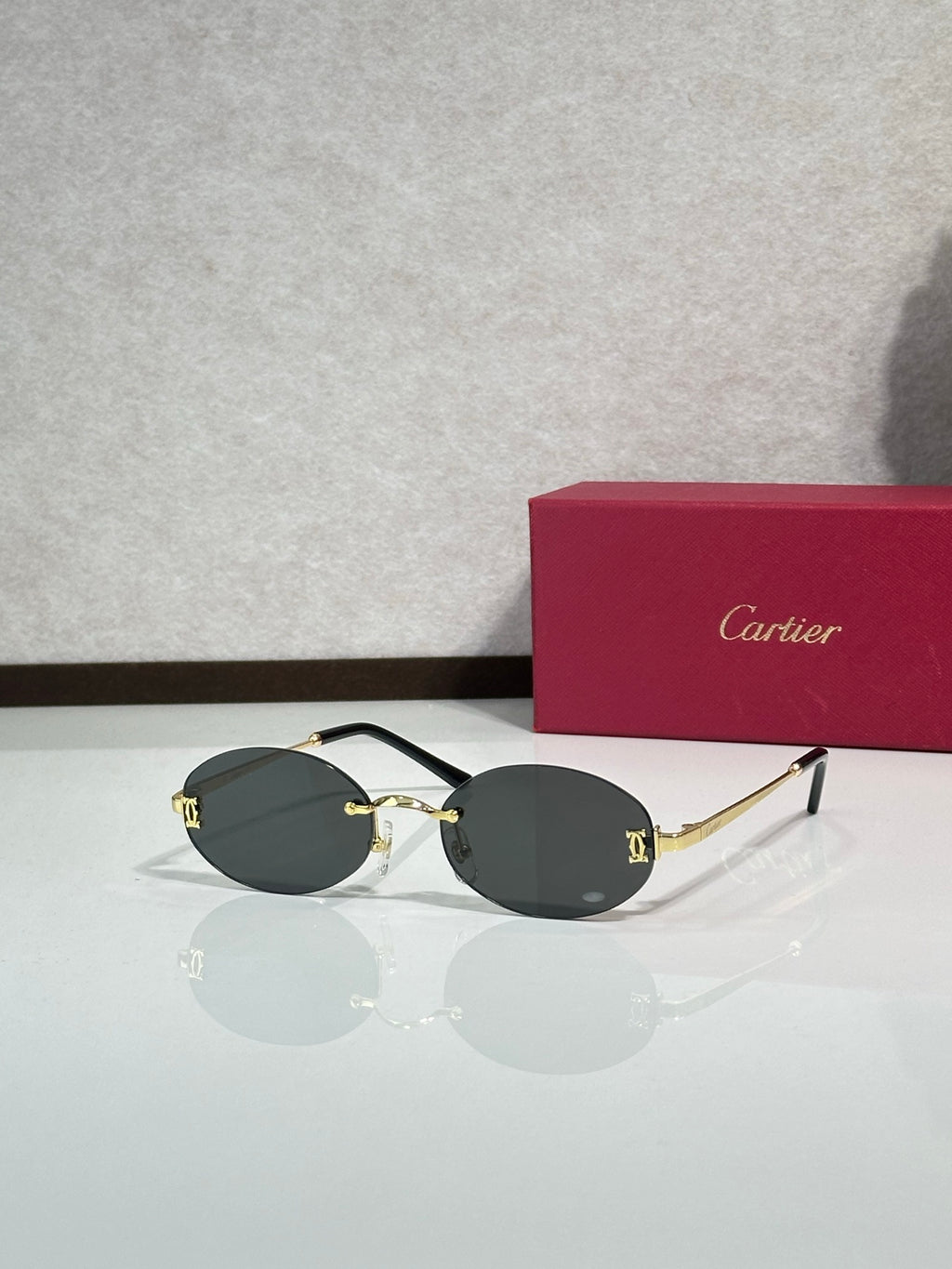 Sunglasses with round dark gray lenses and gold-tone frame with black temples