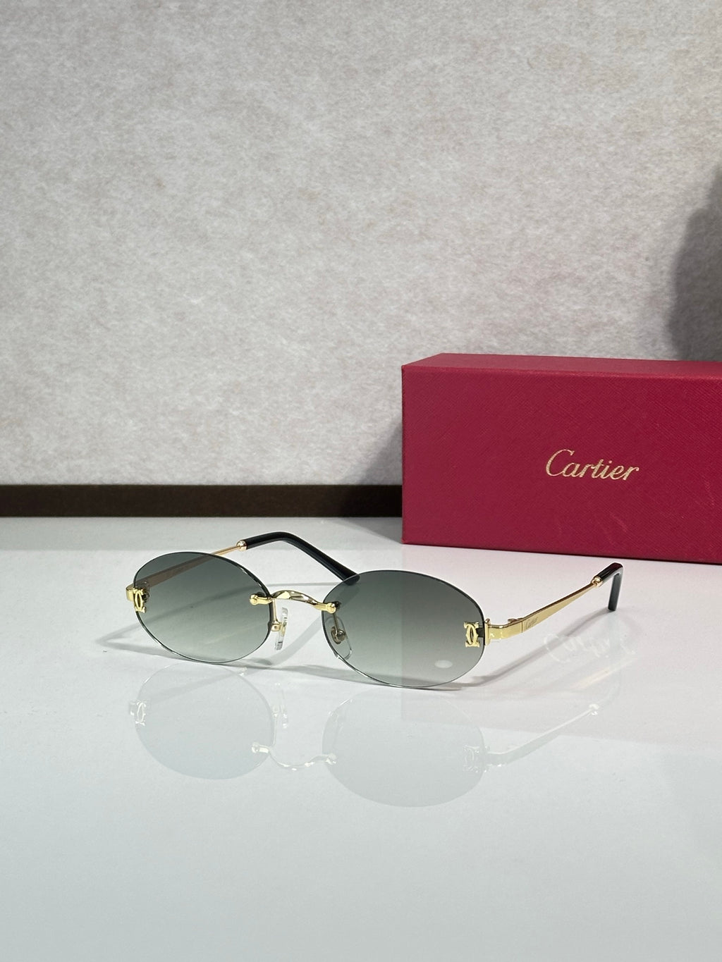 Sunglasses with round light green lenses and gold-tone frame with thin metal temples
