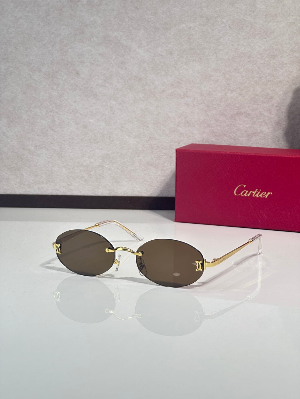 Sunglasses with round dark brown lenses and gold-tone frame with thin metal temples