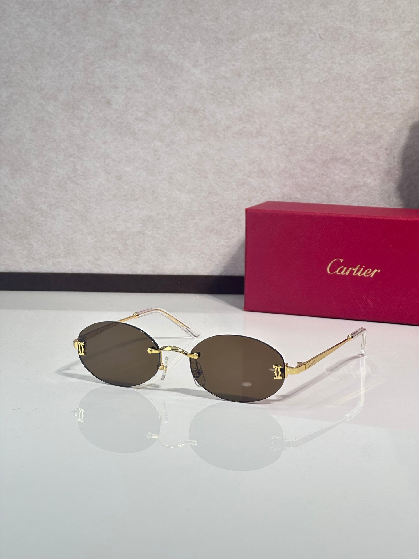 Sunglasses with round dark brown lenses and gold-tone frame with thin metal temples