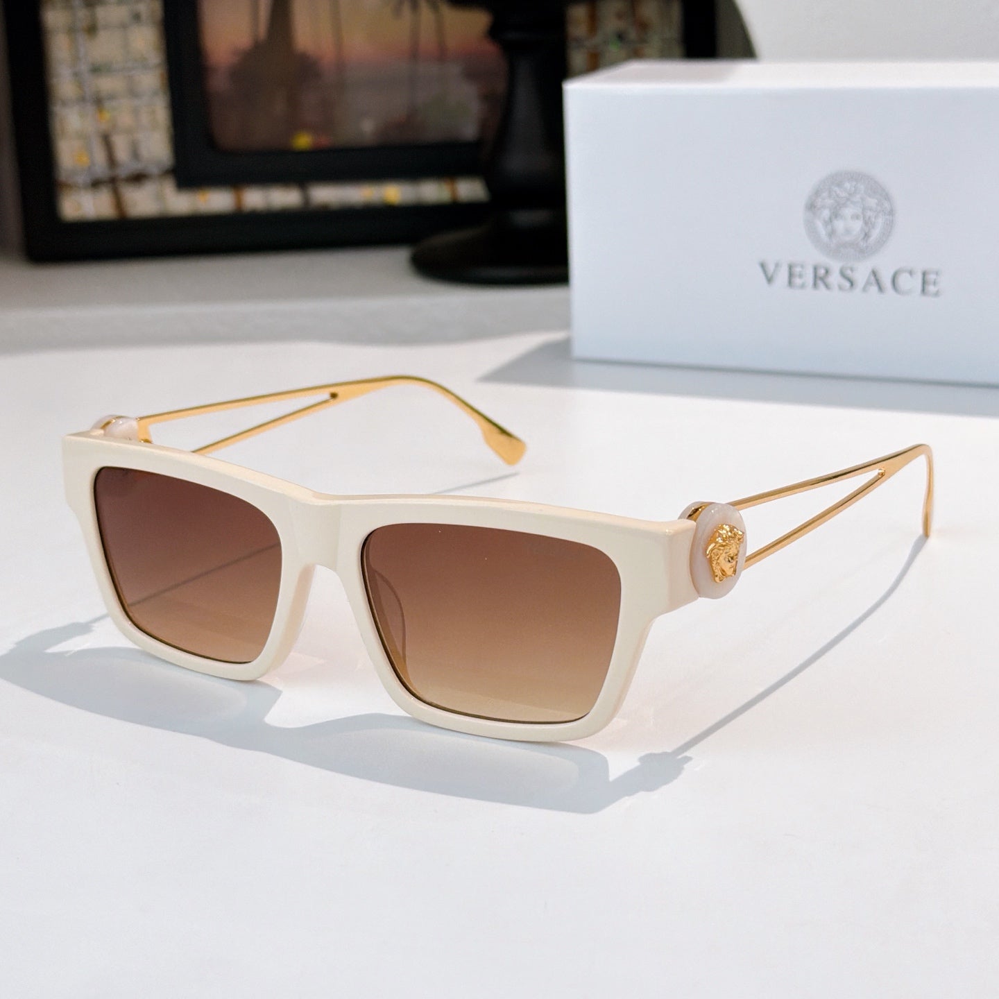 White square sunglasses with brown-tinted lenses and gold-tone arms