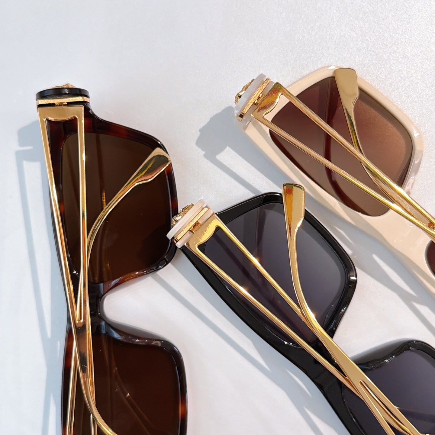 Assorted square sunglasses with gold-tone frames and brown and dark tinted lenses